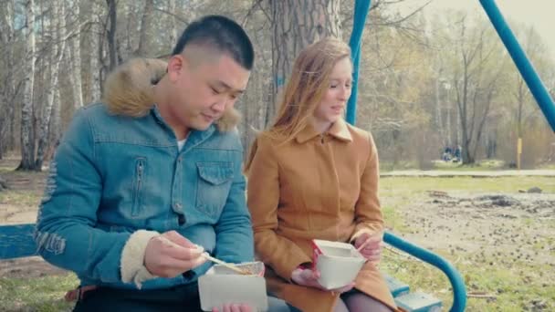 Multirasial novio y novia comiendo comida asiática — Vídeos de Stock