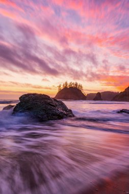 Bir kayalık Pacific Northwest plaj gün batımında