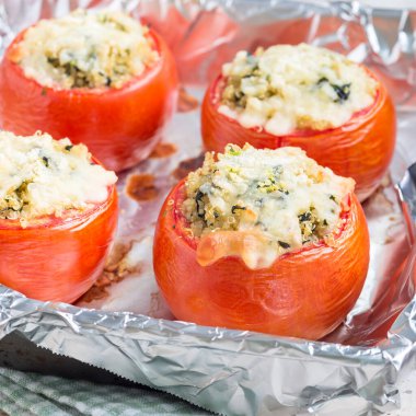 Kainatla doldurulmuş fırında domates ve eritilmiş peynirle kaplı ıspanak. Kare şeklinde.