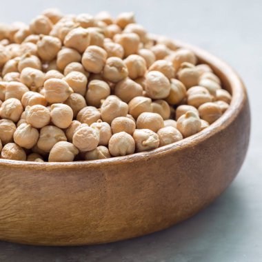 Ahşap kasede pişmemiş kuru nohut, yakın plan, kare.