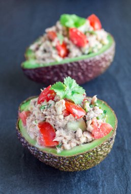 Ton balıklı salata, avokado, domates, kişniş ve limon suyu avokado kasesinde servis edilir.