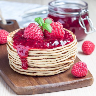 Bir yığın krep ya da ahududu reçelli börek ve ahşap tahtada böğürtlen, kare biçiminde.