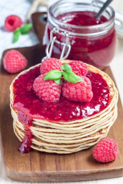 Tahta tahtada ahududu reçelli krep veya börek yığını, dikey.