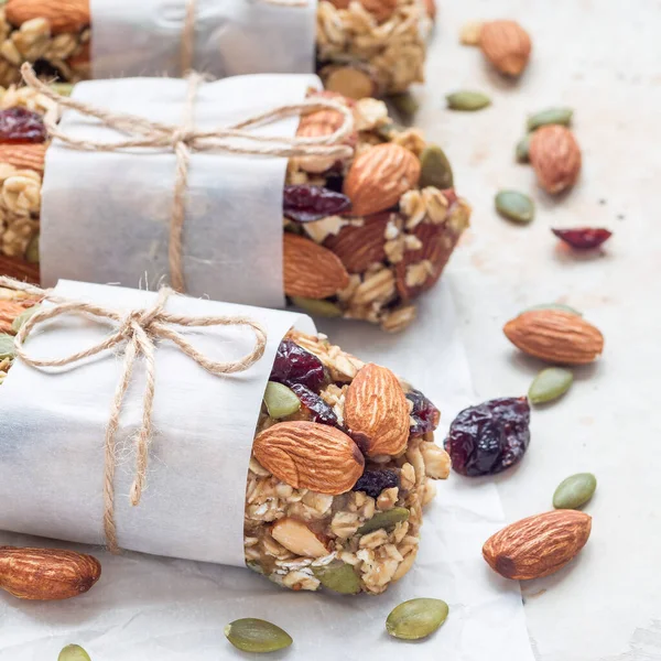 Ev yapımı tahıl gevreği. İncir, yulaf ezmesi, badem, kuru kızılcık ve balkabağı çekirdeği, sağlıklı atıştırmalık, kare format.