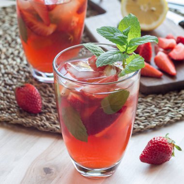 Bir bardak ferahlatıcı buzlu çay. Çilekli ve naneli. Kare şeklinde.