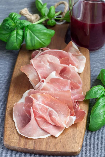 Prosciutto Prosciutto Tavola Legno Foglie Basilico Sullo Sfondo Verticale — Foto Stock