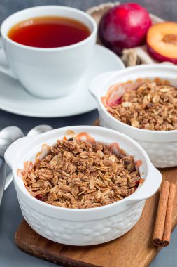 Erikli turta veya yulaf ve baharatlı erik gevreği, bir fırın kabında, dikey