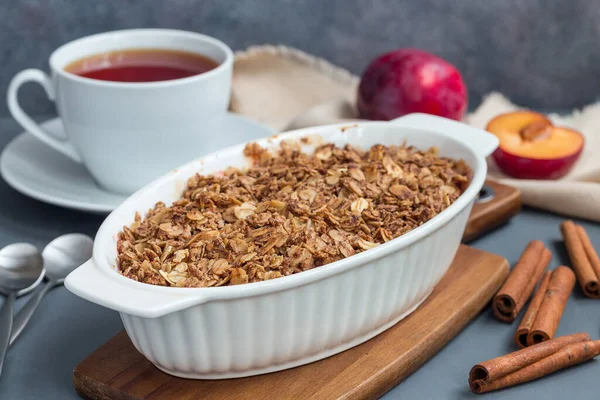 Erikli turta veya yulaf ve baharatlı erik gevreği, bir fırın kabında, yatay