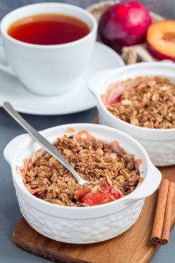 Erikli turta veya yulaf ve baharatlı erik gevreği, bir fırın kabında, dikey