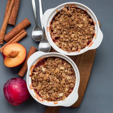 Erik parçacıklı turta veya yulaf ve baharatlı erik gevreği, bir kabın içinde, üst görünümde, kare biçiminde.