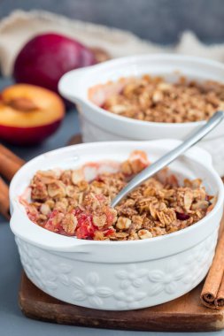 Erikli turta veya yulaf ve baharatlı erik gevreği, bir fırın kabında, dikey