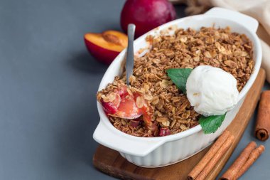 Erikli turta veya yulaf ve baharatlı erik gevreği, vanilyalı dondurma topu ile servis edilir, fırın kabında, yatay, kopyalama alanı