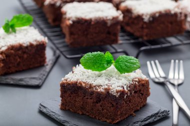 Hindistan cevizi taneli ev yapımı brownie, İsveç tatlısı Karleksmums, kare şeklinde kesilmiş, taş tabakta, yatay.