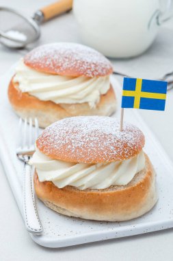 Geleneksel İsveç tatlı Semla veya Shrove çörek, badem ezmesi ve krem şanti ile doldurulmuş, süt ile servis edilir, dikey