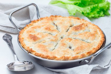 Mercimek, mantar, patates, havuç ve yeşil bezelyeyle kaplı vejetaryen turtası. Kabartma kabında, yatay olarak.