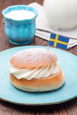 Geleneksel İsveç tatlı Semla, ayrıca Shrove çöreği olarak da bilinir, badem ezmesi ve krem şanti ile doldurulmuş, bir süt ile servis edilir, dikey