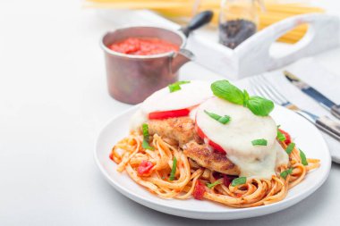 Domates ve mozzarella peynirli tavuk caprese, linguine, domates sosu ve fesleğen ile servis edilir, yatay, kopyalama alanı