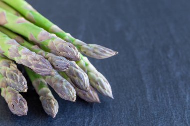 Koyu arkaplanda yeşil kuşkonmaz sürüsü, yatay, kopyalama alanı