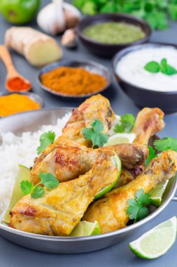 Yunan yoğurt ve baharatlarıyla marine edilmiş Hint tavuğu tandır. Limon dilimleri, kişniş ve basmati pilavı ile servis edilir.