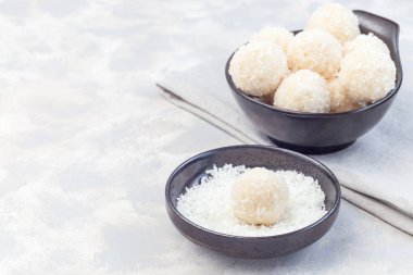 Sağlıklı ev yapımı çiğ paleo enerji hindistan cevizi topları seramik bir kasede, yatay, kopyalama alanı