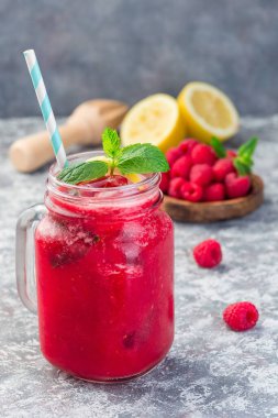 Ahududu, limon ve naneli limonata. Kavanozda köpüklü su, dikey.