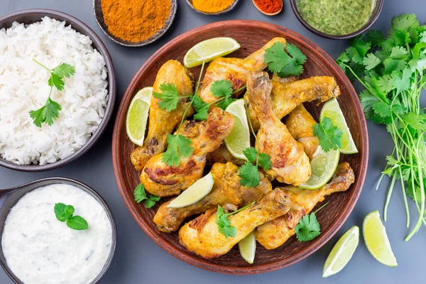 Yunan yoğurt ve baharatlarıyla marine edilmiş Hint tavuğu tandır. Limon dilimleri ve kişniş ile servis edilir. 