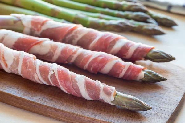 Tahtada yeşil kuşkonmaz ve pastırma. Sağlıklı aperatifler için malzemeler.