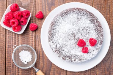 Çikolatalı kek, İsveçli tatlı Kladdkaka, tabakta, krema şekeri ve ahududu ile süslenmiş, yatay, üst görünüm
