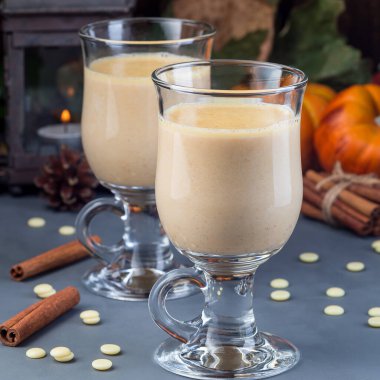 Balkabağı ve baharatlı sıcak beyaz çikolata, arka planda sonbahar süslemeleri, kare