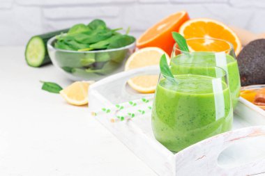 Yeşil detoks smoothie avokado, ıspanak, salatalık, portakal, limon ve bal, ahşap tepside, yatay, kopyalama alanı