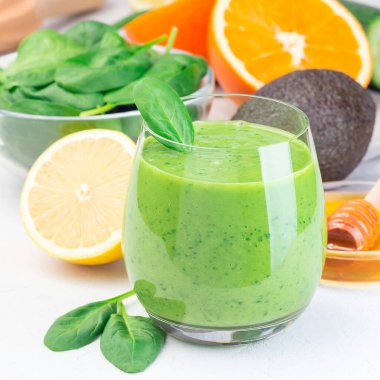 Yeşil detoks smoothie with avokado, ıspanak, salatalık, portakal, limon ve bal, in glass, square format