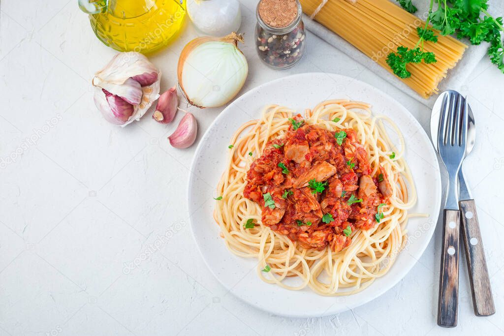Spaghetti with tuna and tomato basil sauce garnished with parsley, horizontal, top view,  copy space