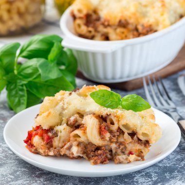 Biftek, peynir ve domatesli makarna güveci, kare şeklinde.