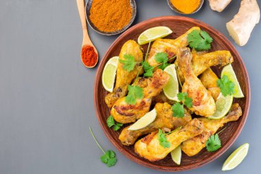 Hint tavuk tandırı, Yunan yoğurdu ve baharatlarıyla marine edilmiş, limon dilimleri ve kişniş ile servis edilmiş, yatay, üst manzara, kopyalama alanı