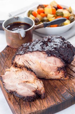 Ballı, parmesanlı ve soya soslu domuz omuzu, yavaş pişirme makinesinde ya da çömlek tenceresinde, tahta bir tahtanın üzerinde, dikey 