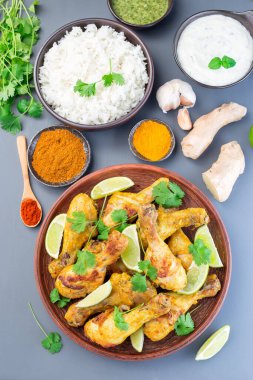 Yunan yoğurt ve baharatlarıyla marine edilmiş Hint tavuğu tandır. Limon dilimleri ve kişniş ile servis edilir. 