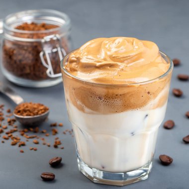 Buzlu Dalgona kahvesi, koyu gri arka planda moda Kore içeceği, kare format