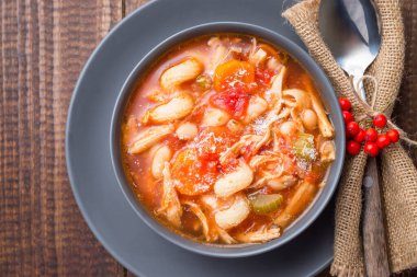 Hindi, makarna, havuç, kereviz, domates ve canellini fasulyesi çorbası, parmesan peyniri ile süslenmiş, sonbahar süsüsüyle süslenmiş, ABD Şükran Günü ziyafetini yansıtan, yatay, üst manzara, fotokopi alanı, yakın çekim alanı