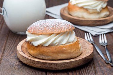 Geleneksel İsveç tatlı Semla, ayrıca Shrove çöreği olarak da bilinir, badem ezmesi ve krem şantili, sütle servis edilir, yatay