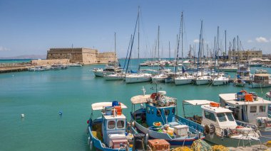 Yunanistan 'da Heraklion, Girit adasında 18 Temmuz 2019' da bir Rocca a Mare kalesi ve tekneli liman manzarası.