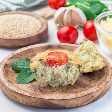 Kinoalı, peynirli ve domatesli, ahşap bir tabakta kesilmiş ıspanaklı tuzlu kekler, kare şeklinde, yakın plan.