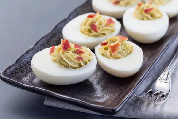 Huevos Rellenos Aguacate Yema Huevo Mayonesa Adornados Con Tocino Horizontales —  Fotos de Stock