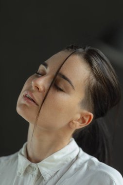 yüzünde saç şerit ile beyaz gömlek muhteşem esmer kadın. siyah saçlı moda genç kadın kapalı. kadın portre kavramı. Yeşil gözlü kadın. İskandinav tarzı güzel sanatlar kadın portre