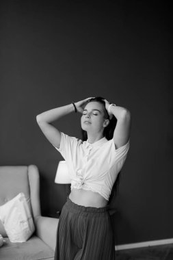 geniş bacaklar ve beyaz gömlek ile kırmızı moda tava muhteşem esmer kadın siyah ve beyaz portre. siyah saçlı moda genç kadın kapalı. rahat ev konsepti. güzel sanatlar kadın portre