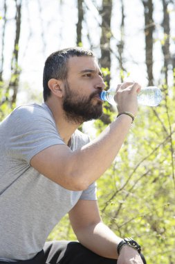 Sırt çantasıyla ormanda yürüyen adam.