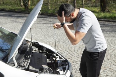 Bozuk araba ile stresli adam başarısız motor bakarak, onu düzeltmek için çalışıyor
