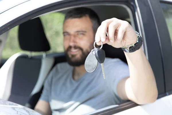 彼の車の中に座っている若い男の手の中の車のキー — ストック写真