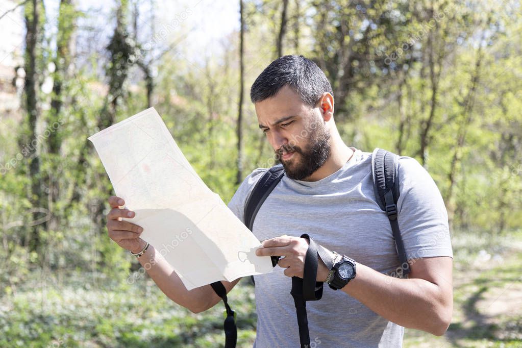 Male hiker using a map to locate the destination