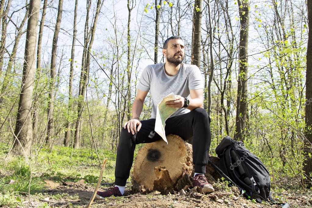 Male hiker using a map to locate the destination