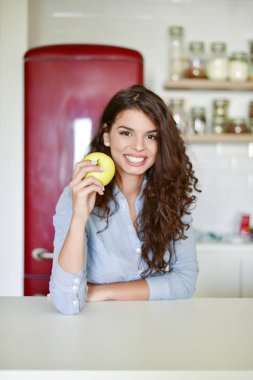 Genç kadın elma yiyor.